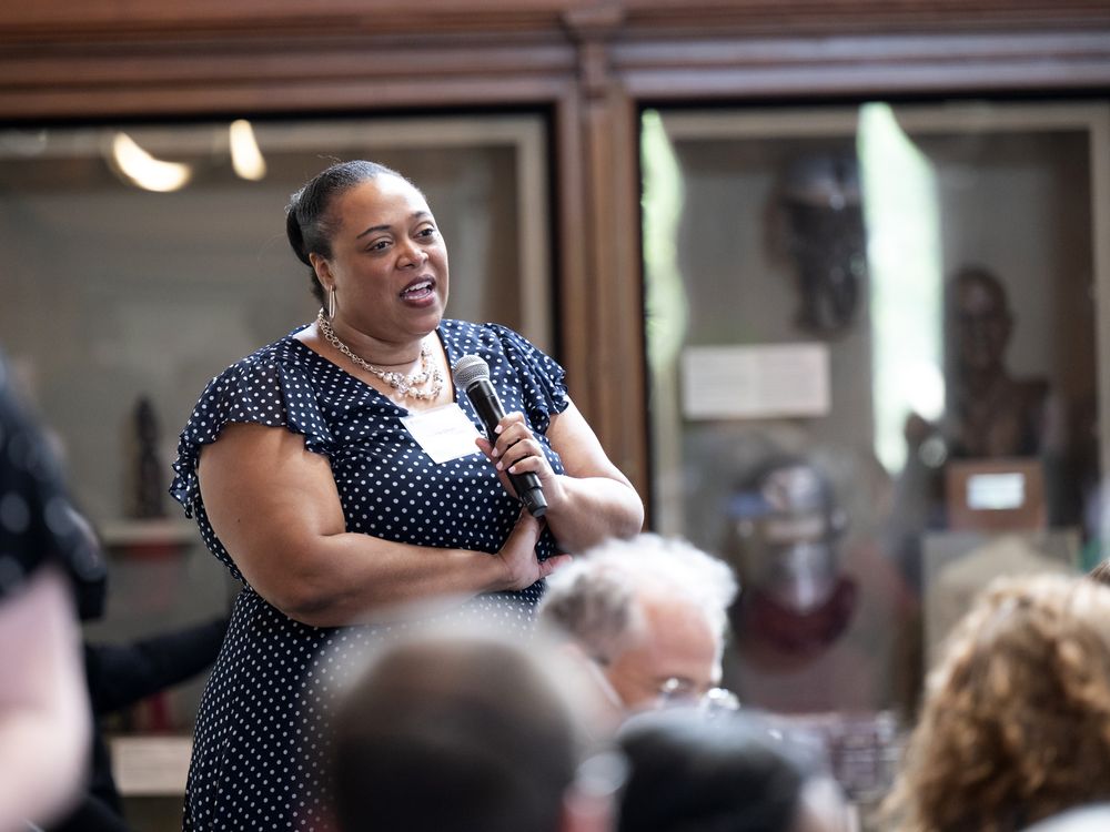 Woman with crossed arms holds a microphone