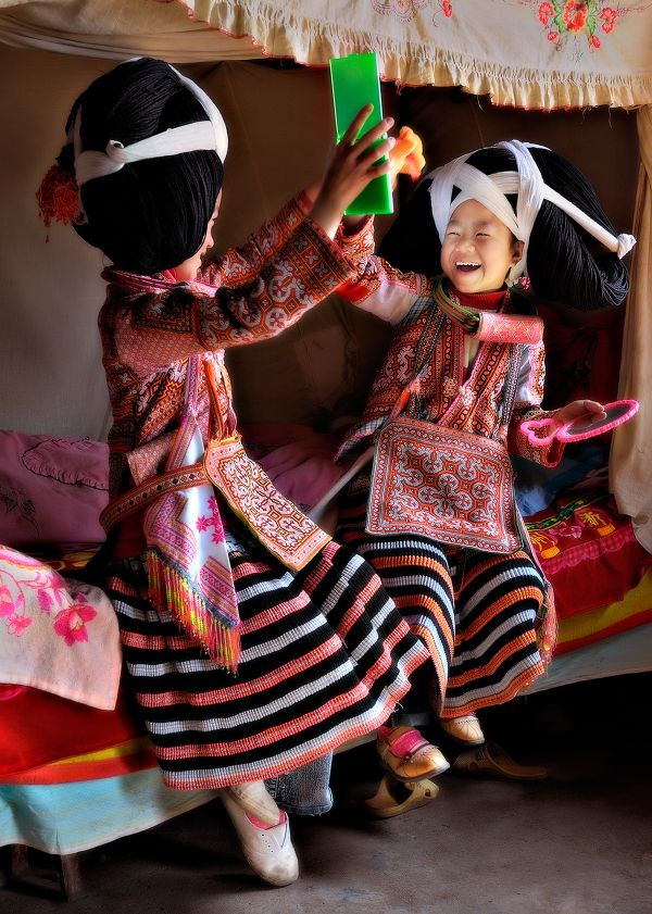 Longhorned Miao girls playing with mirrors thumbnail