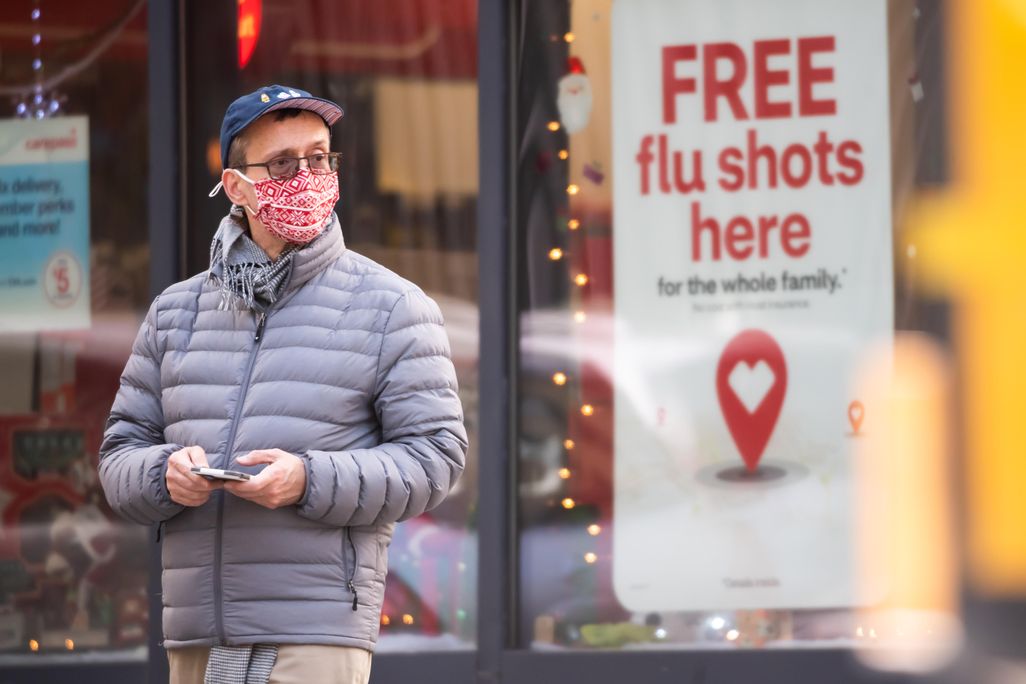 A person stands by a sign advertising flu shots at CVS as the city continues the re-opening efforts following restrictions imposed to slow the spread of coronavirus on December 01, 2020 in New York City. 