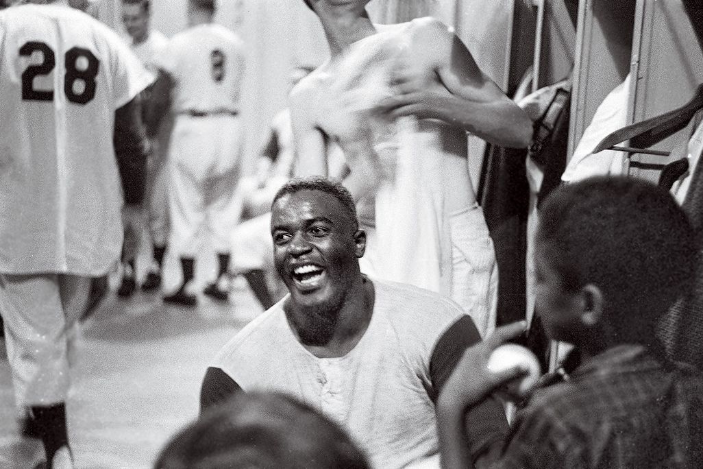 Jackie Robinson smiling in a locker room