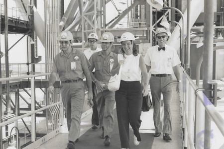 Ann Montgomery, lead crew systems engineer during the Apollo program, on the swing arm of the launch pad at Kennedy Space Center with other NASA employees, circa 1970.
