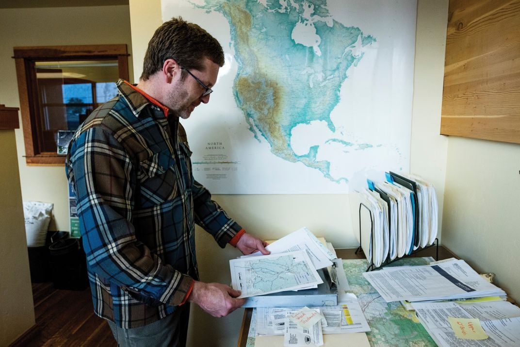 a man in an office studies maps