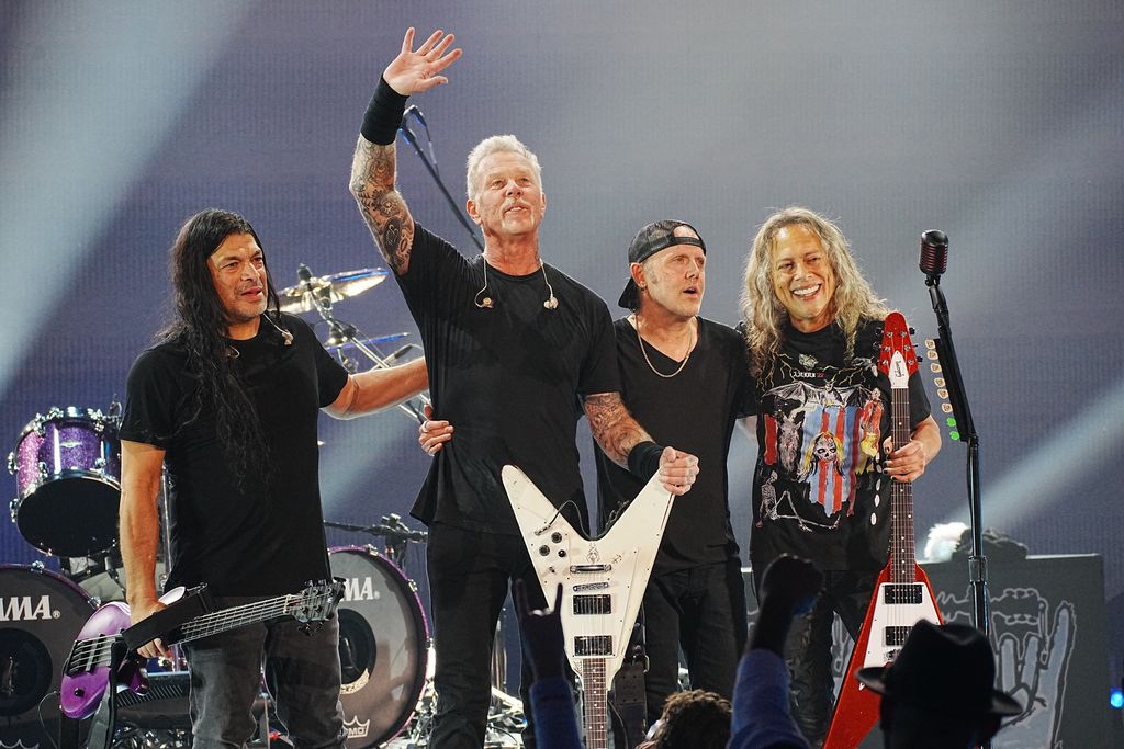 Four band members standing next to each other on a stage