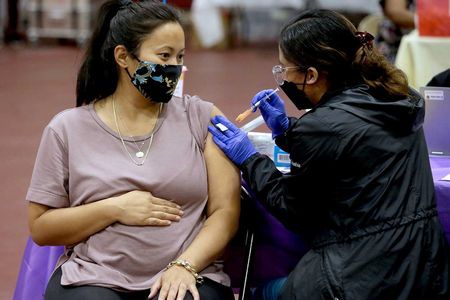 A woman who is six months pregnant receives a Covid booster shot in Los Angeles. The CDC advises pregnant women to get vaccinated.