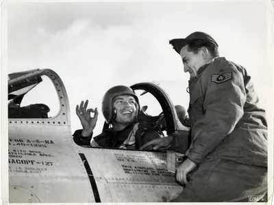 Lt. Ward Hitt, Jr., sitting in the cockpit of his North American F-86A Sabre fighter, gives his crew chief the OK hand sign, South Korea.