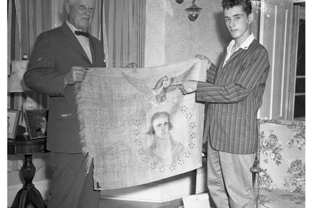 Clarence Barnes and Craig Wade with the banner in the Wade family home.