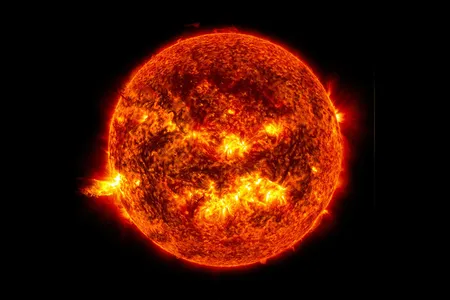 A solar flare erupts from the sun on June 20, 2013, seen at the left of the image.