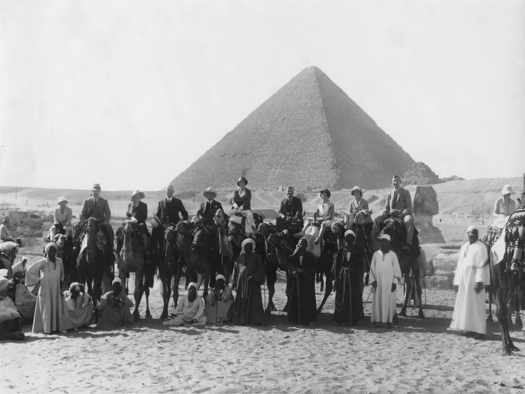 Camel tour in front of one of the Pyramids of Giza in          Egypt, circa 1920s to 1930s