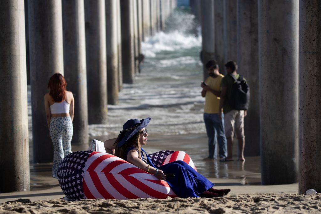 A person sitting in an American flag chair on the beach