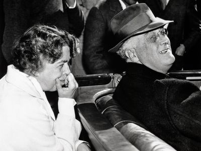 Eleanor Roosevelt leans forward from the back seat of the Roosevelt car to catch a comment from her husband, Franklin, as they campaign for his fourth term as president. 