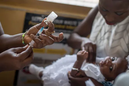 A baby receives a mallaria vaccine from a nurse at the maternity ward of the Ewin Polyclinic in Ghana in 2019.
