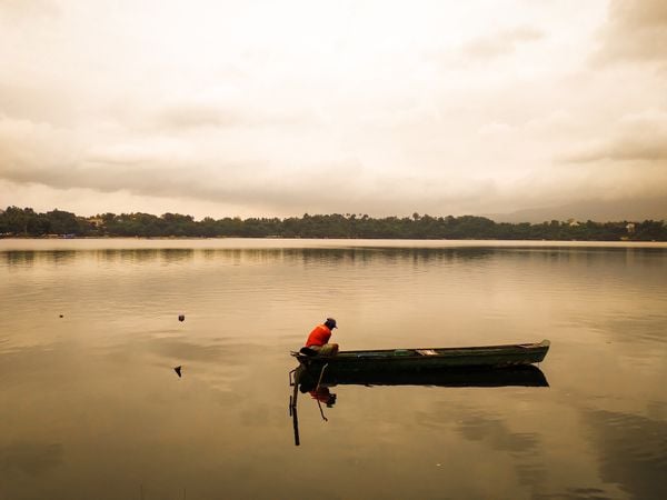 A man embracing solitude in fishing on the calm Sampaloc Lake thumbnail