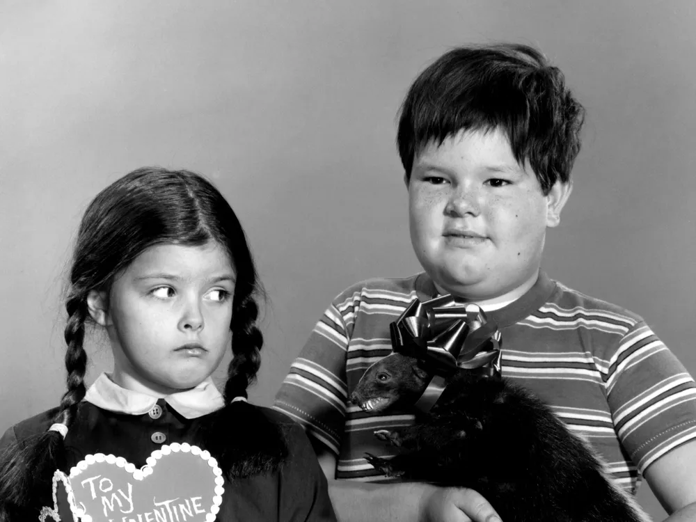 Wednesday (Lisa Loring) poses with a valentine with her brother Pugsley (Ken Weatherwax), who is holding a stuffed animal
