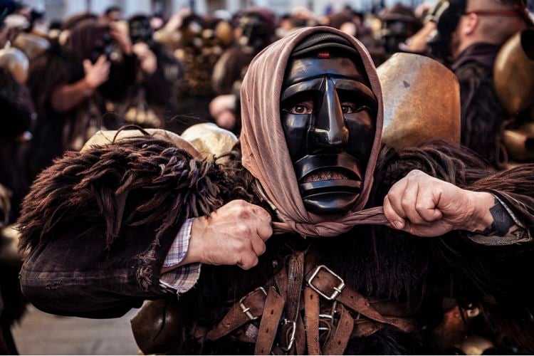 OPENER - Loaded with leather and sheepskins, Salvatore Gungui tightens his headscarf. Although only men dress as Mamuthones, the scarf adds a feminine element.