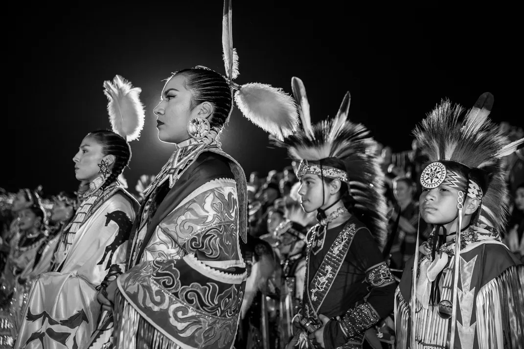 4 - Powwow participants stand and sing the national anthem before the start of an event in San Diego.