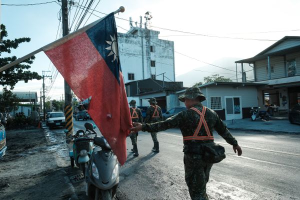 A Taiwanese soldier touches the flag as he passes by. thumbnail