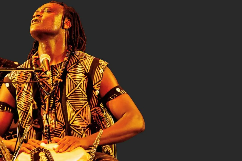 Latyr Sy, a Senegalese percussionist and singer, plays the drums.