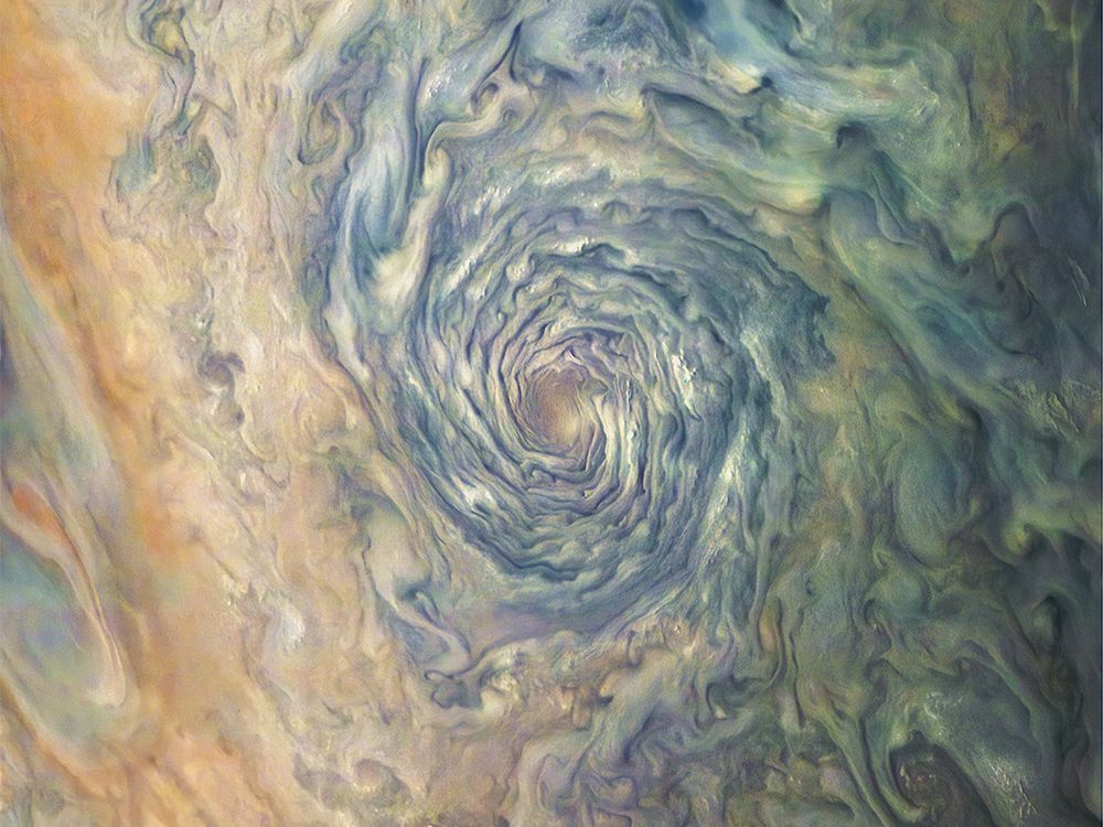 A massive atmospheric vortex on Jupiter is a dizzying swirl of brown, yellow, and green clouds that form a deep tunnel.