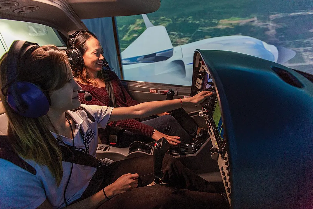 students practice flying on a simulator