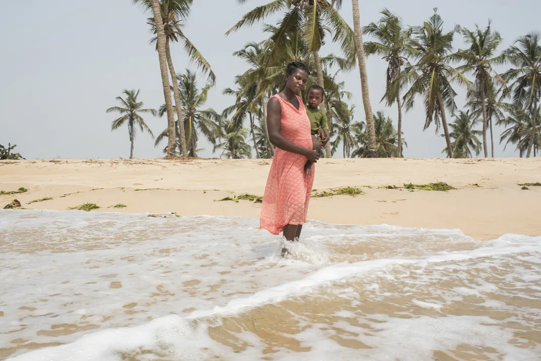 A African mother holds her young son at the beach