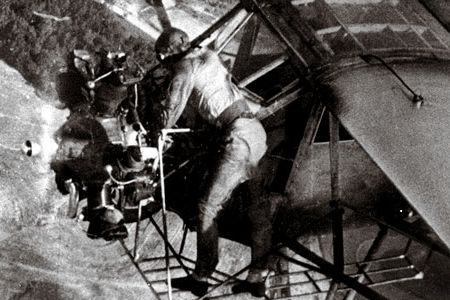 In a 1935 publicity stunt, Fred Key checks the oil in flight.