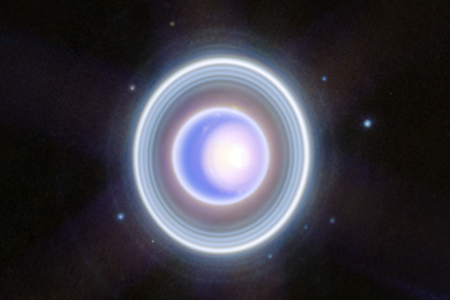 Uranus with its rings and moons, showcasing storms and a polar ice cap on the planet. The new Webb image was produced by combining longer and shorter exposures.