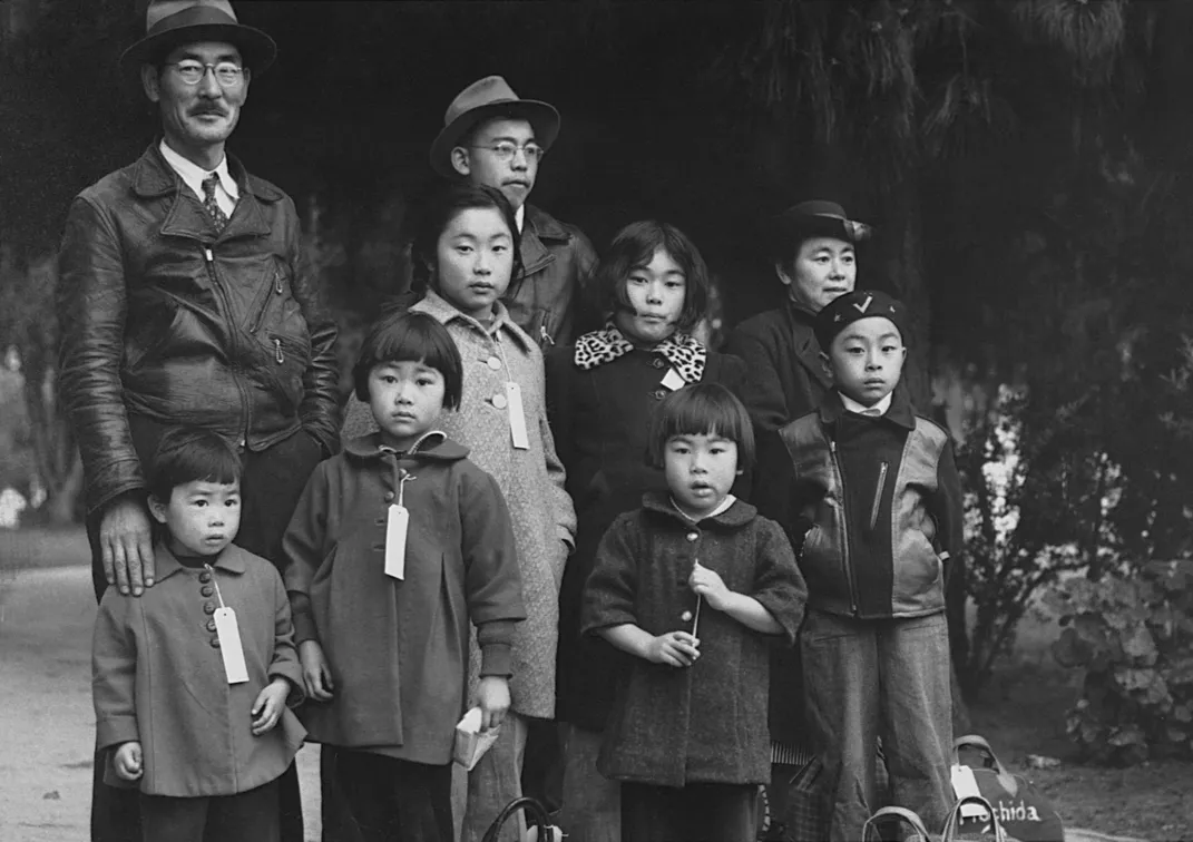 The Japanese American Mochida family waits for a bus to an incarceration camp in Hayward, California, on May 8, 1942.