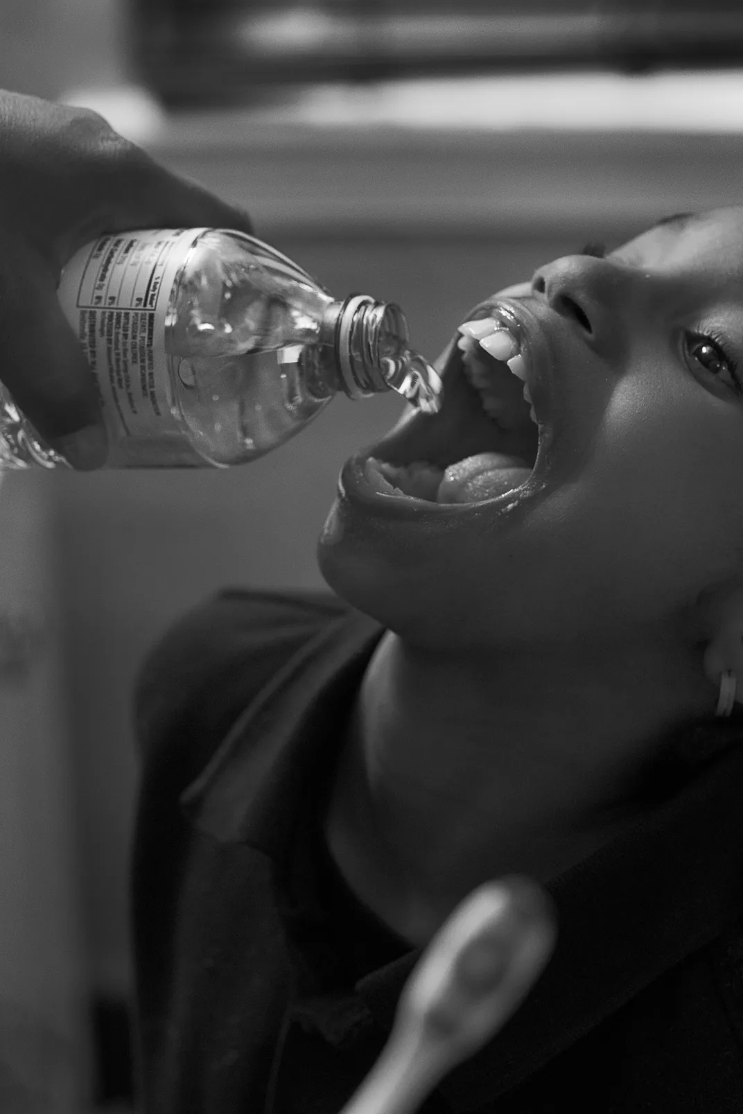 Shea Brushing Zion's Teeth with Bottled Water in Her Bathroom, Flint, Michigan, 2016-1017