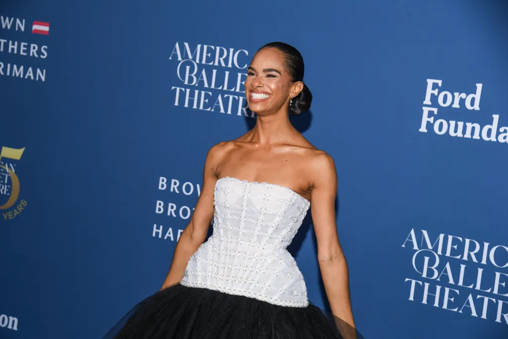 Person in a black and white dress smiles