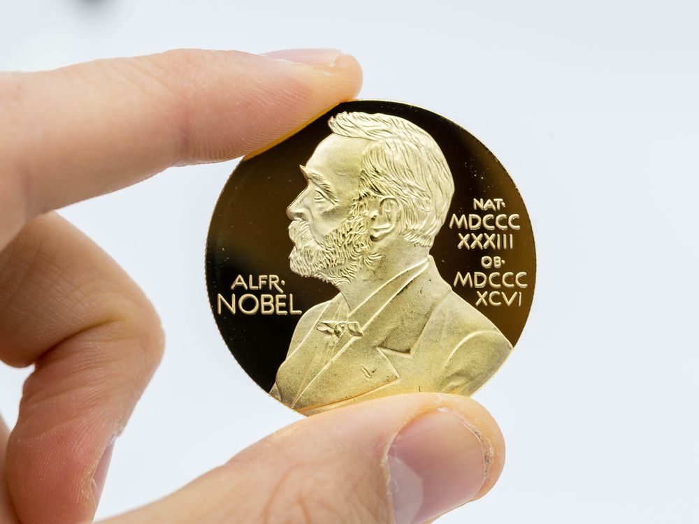 The gold medal that recipients are awarded, featuring the profile of alfred nobel.