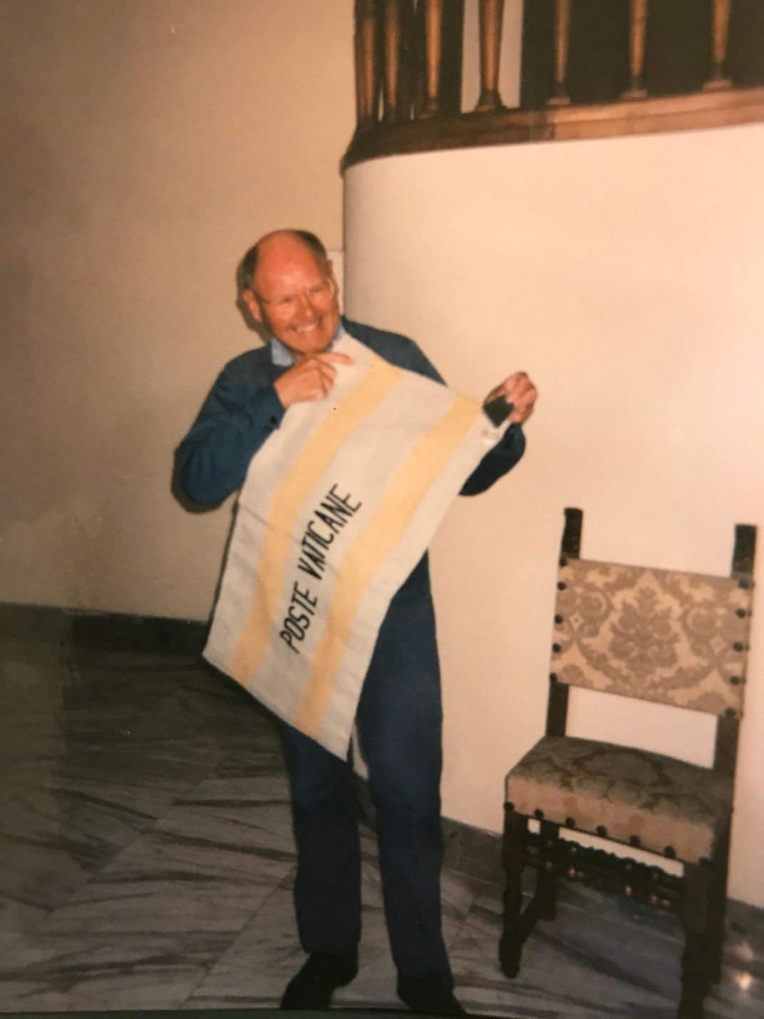 Father Reginald Foster holding a banner