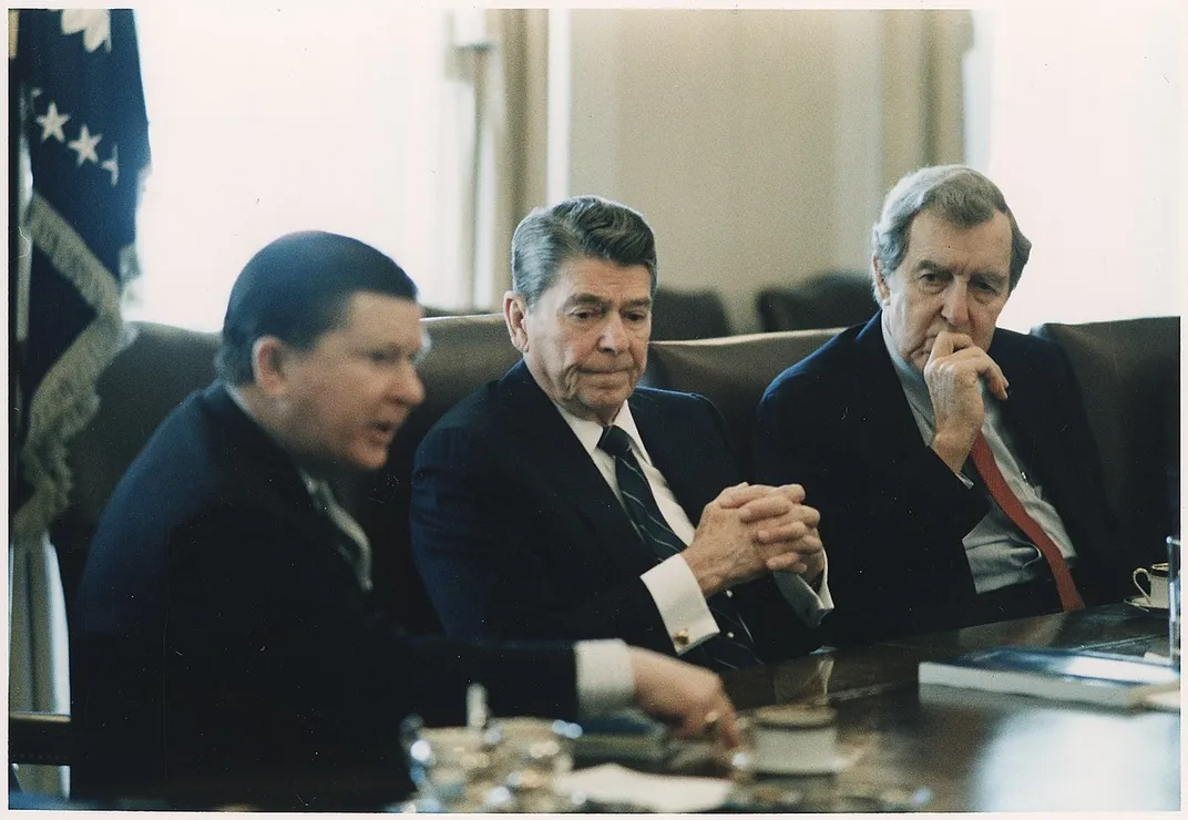 Reagan receives the 1987 Tower Commission Report on the Iran-Contra affair.