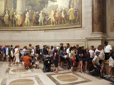 Visitors wait in line at the National Archives to view the Declaration of Independence (against the wall, center right), preserved under glass and special lighting, ahead of the Fourth of July Independence Day holiday in Washington, July 3, 2013.