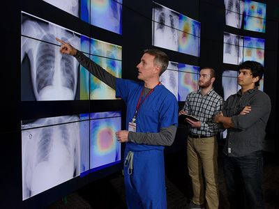 Stanford radiologist Matthew Lungren, left, meets with graduate students Jeremy Irvin and Pranav Rajpurkar to discuss the results of detections made by the algorithm.