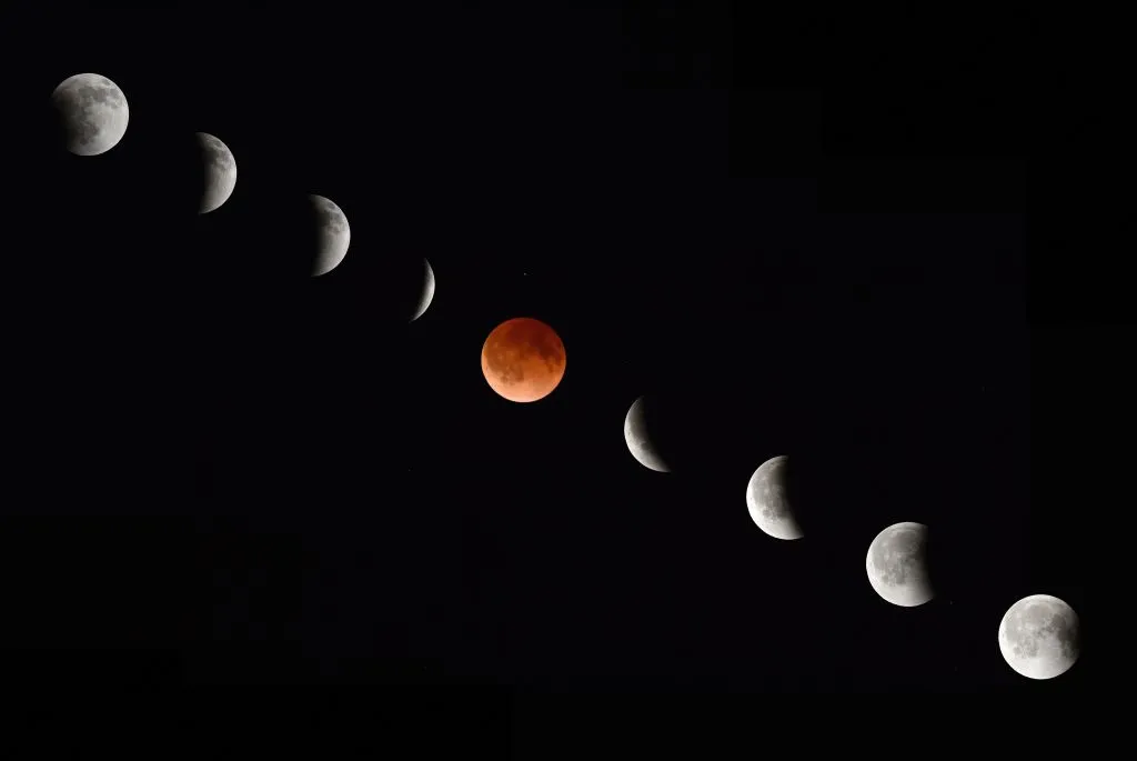 phases of a total lunar eclipse, arranged in a diagonal from upper left to bottom right, with the blood-red moon at the center
