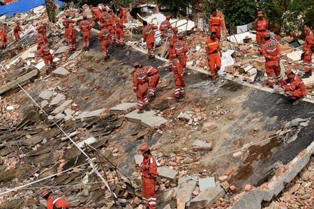 Rescue workers look through the ruins left by the August 3, 2014 earthquake.