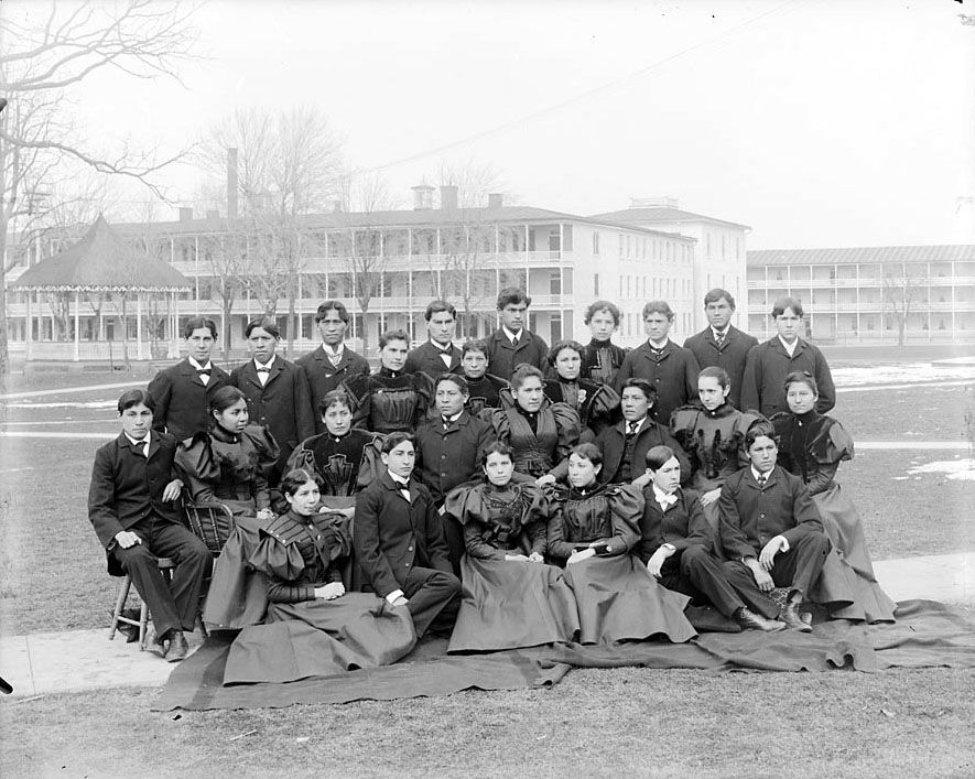 Group_of_Male_and_Female_Students;_Brick_Dormitories_And_Bandstand_in_Background_1879.jpg
