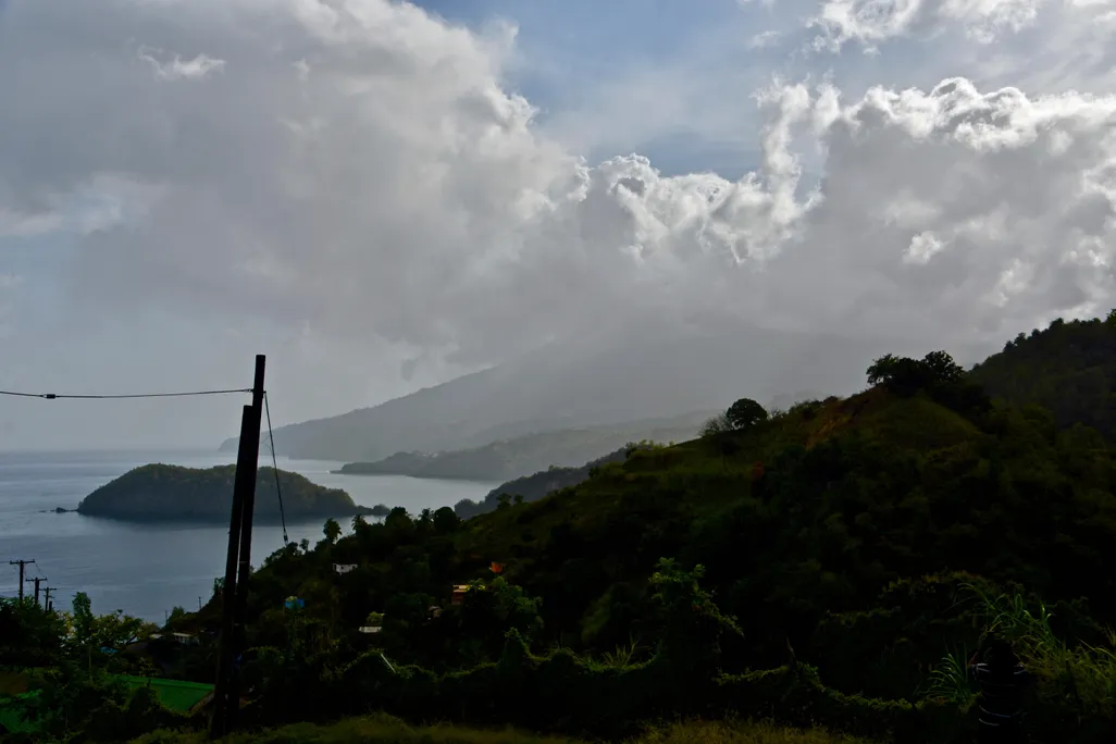A photograph shows La Soufrière volcano surrounded by ash in the distance