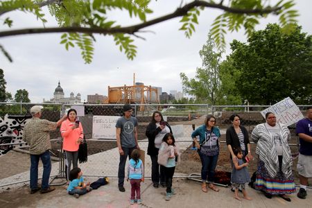 Protestors stand in front of the Walker Sculpture Garden's construction fence on Saturday, May 27, 2017.