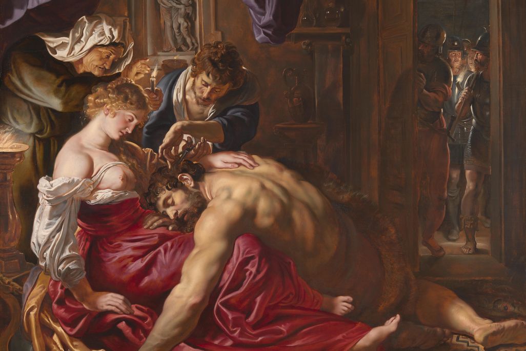 A large painting depicting a muscular Samson sprawled on the floor, resting his head in the lap of Delilah while someone else cuts some of his hair