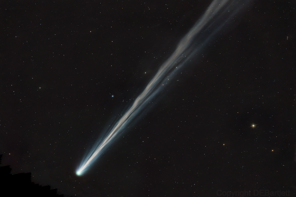 A white comet streaks across dark space