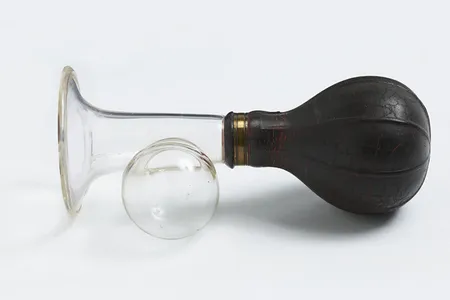 Manual breast pump with black bulb, dating to sometime between 1920 and 1959
