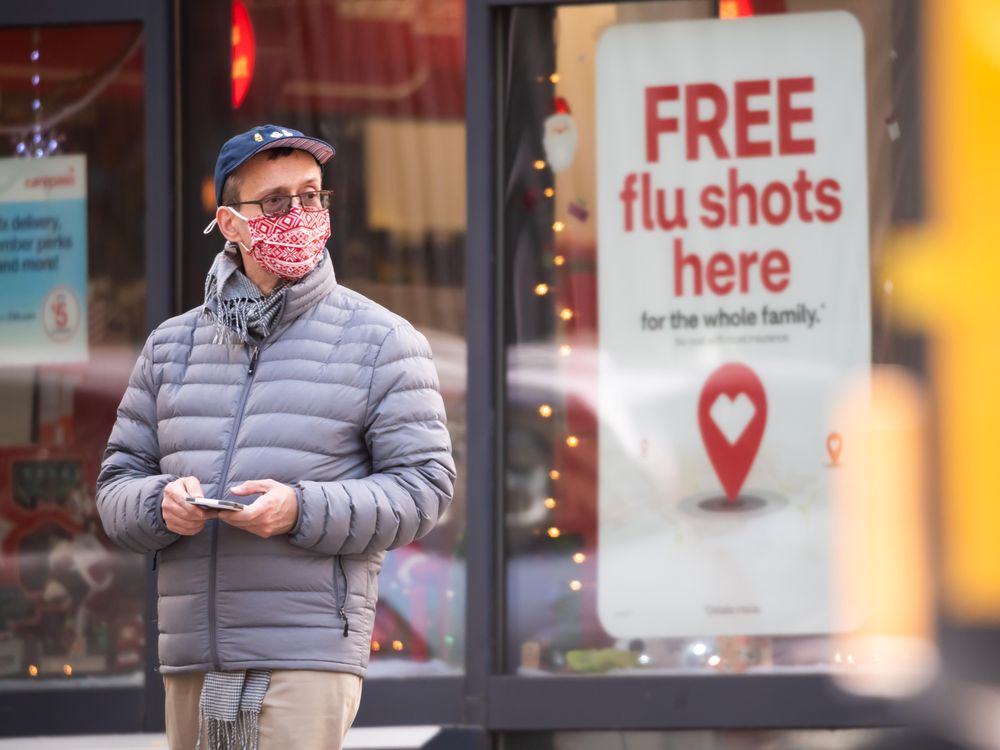 A person stands by a sign advertising flu shots at CVS as the city continues the re-opening efforts following restrictions imposed to slow the spread of coronavirus on December 01, 2020 in New York City. 