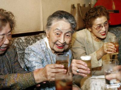 A bar proprietress drinks during her 101st birthday party at her tiny bar in Tokyo.