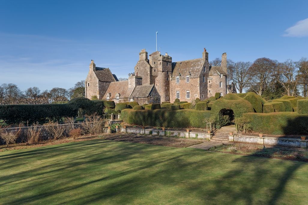 Large Gray stone castle overlooking vast green landscape