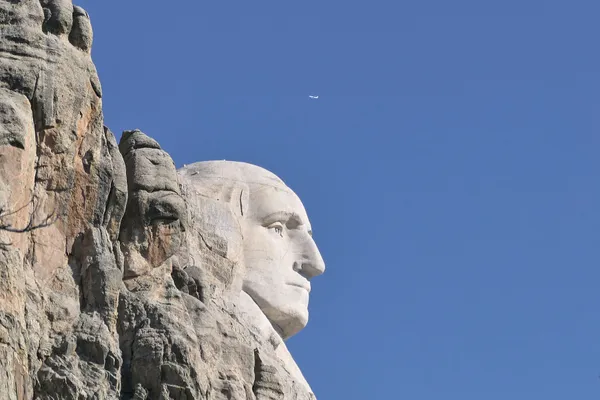 Jet flying above Mount Rushmore George Washington carving. thumbnail