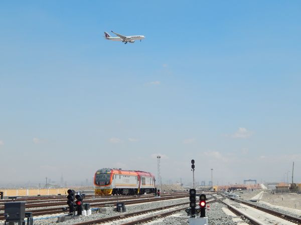 Aeroplane flies over train. thumbnail