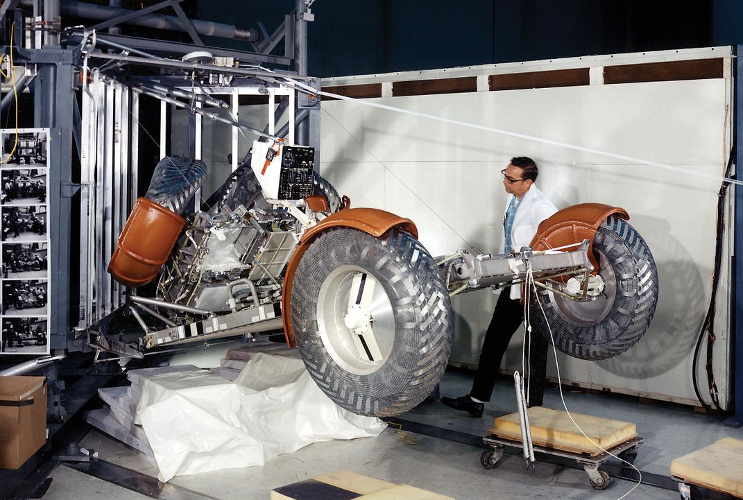 testing lunar rover deployment as man in white jacket inspects