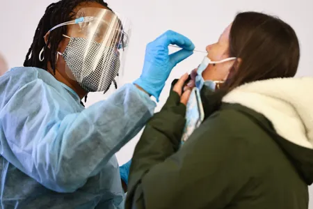 A person receives a Covid-19 nasopharyngeal swab at a testing site in Los Angeles International Airport on December 21, 2021.&nbsp;