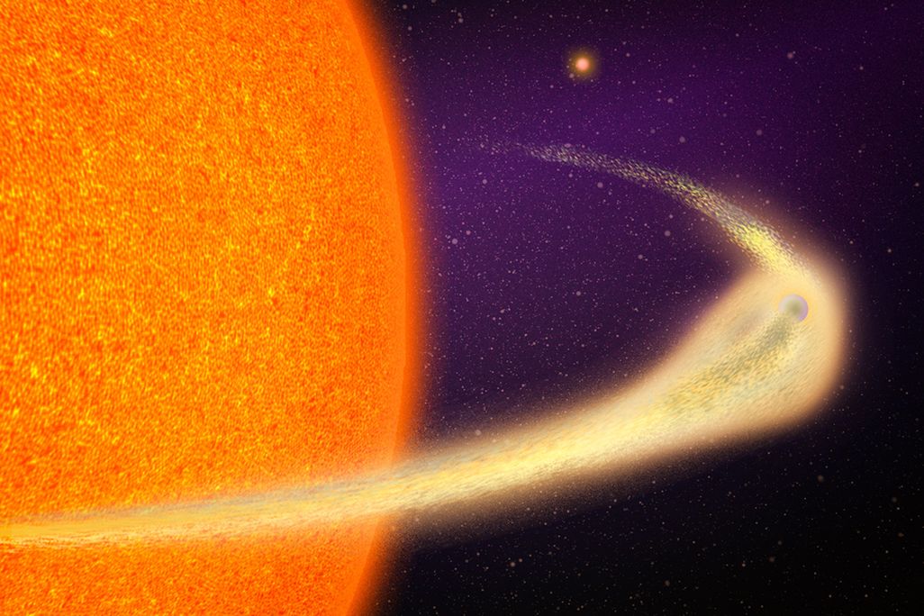 An artistic rendering of a planet closely orbiting its host star, losing material in a dusty comet-like tail.